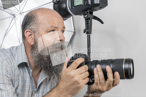 Image of bearded senior photographer at work