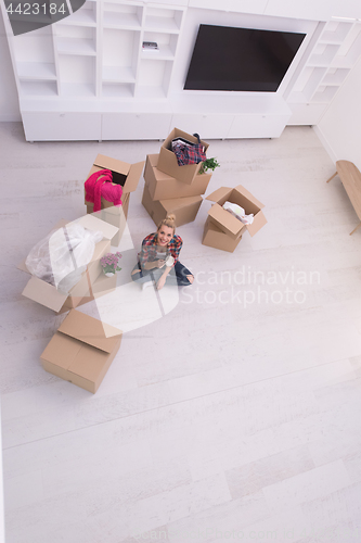 Image of woman with many cardboard boxes sitting on floor