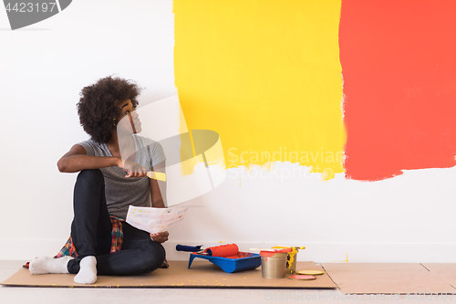 Image of back female painter sitting on floor