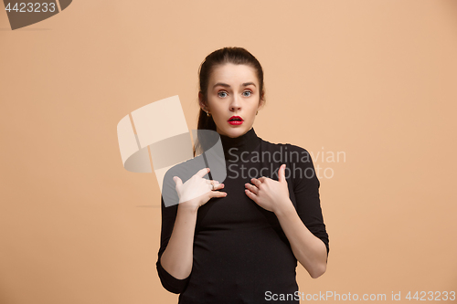 Image of Beautiful woman looking suprised isolated on pastel brownish beige