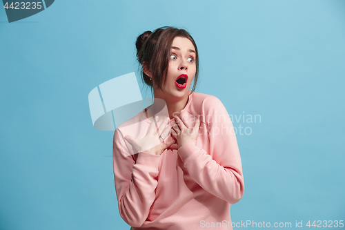 Image of Beautiful woman looking suprised isolated on blue