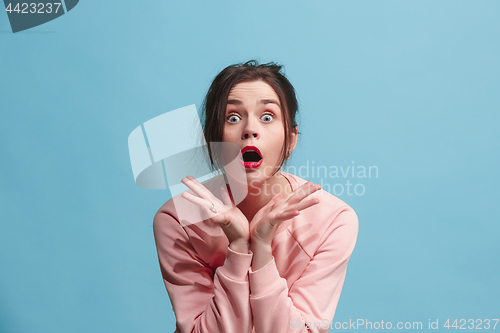 Image of Beautiful woman looking suprised isolated on blue