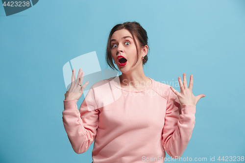 Image of Beautiful woman looking suprised isolated on blue