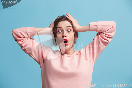 Image of Beautiful woman looking suprised isolated on blue