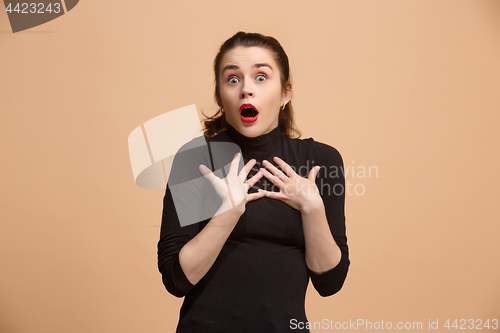 Image of Beautiful woman looking suprised isolated on pastel brownish beige