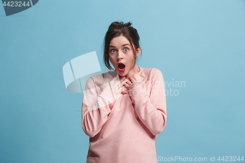 Image of Beautiful woman looking suprised isolated on blue