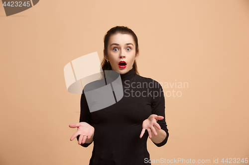 Image of Beautiful woman looking suprised isolated on pastel brownish beige