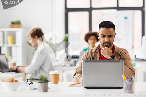 Image of indian man with laptop computer at office