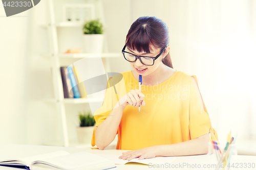 Image of happy asian young woman student learning at home