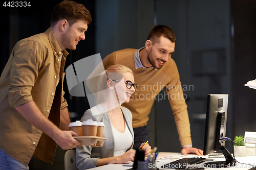 Image of business team with computer working late at office