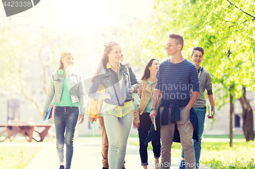 Image of group of happy teenage students walking outdoors