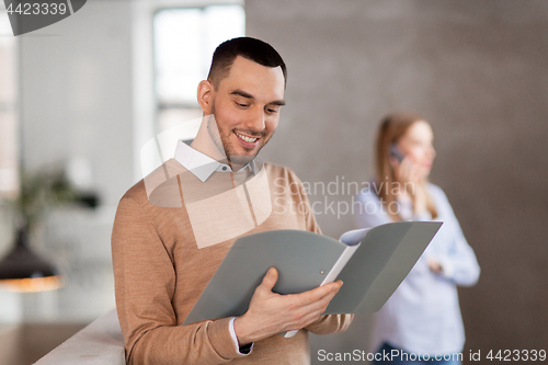 Image of smiling male office worker with folder