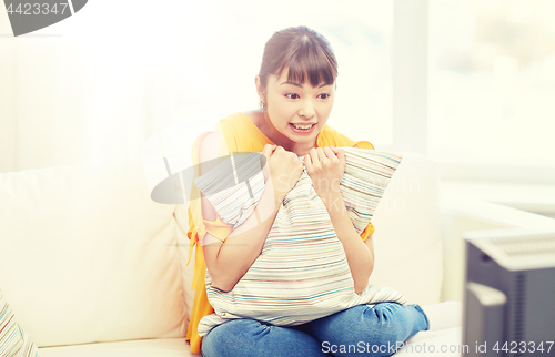 Image of asian young woman watching tv at home