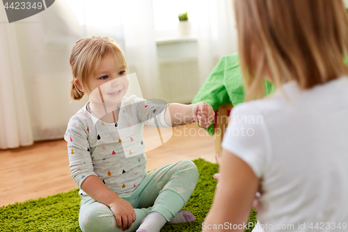 Image of girls playing rock-paper-scissors game at home