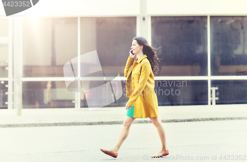 Image of smiling young woman or girl calling on smartphone