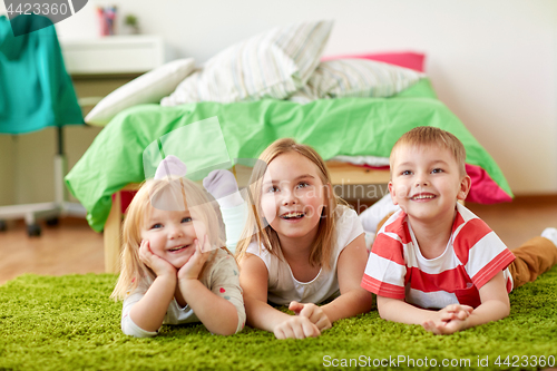 Image of happy little kids lying on floor or carpet