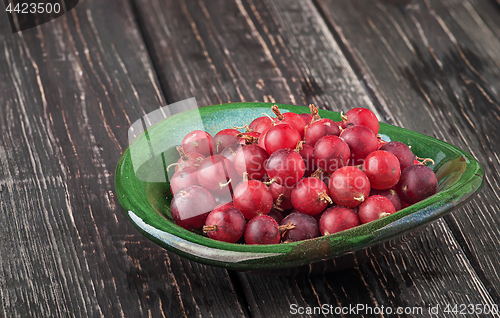 Image of Red gooseberry in clay bowl