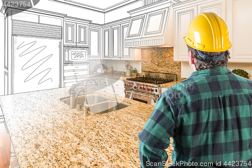 Image of Male Contractor with Hard Hat Looking At Custom Kitchen Drawing 