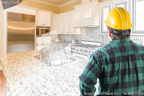 Image of Male Contractor with Hard Hat Looking At Custom Kitchen Drawing 