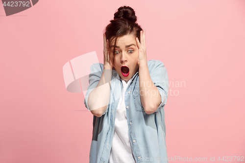 Image of Beautiful woman looking suprised isolated on pink