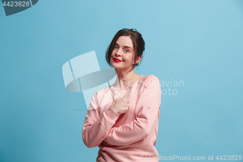 Image of The happy business woman standing and smiling against pastel background.