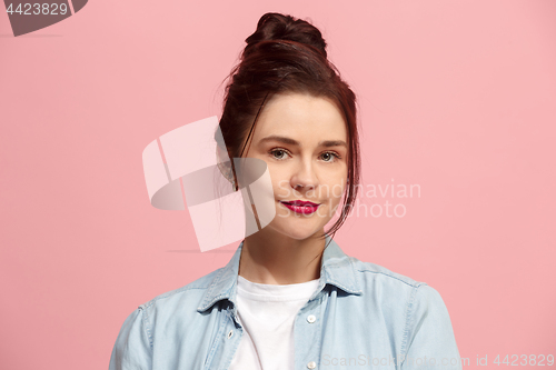 Image of The happy business woman standing and smiling against pink background.