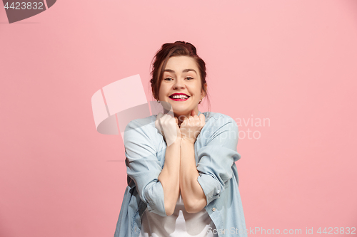 Image of The happy business woman standing and smiling against pink background.