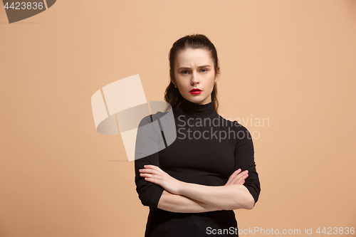 Image of The serious business woman standing and looking at camera against pastel background.