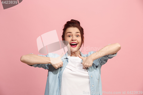 Image of The happy business woman standing and smiling against pink background.