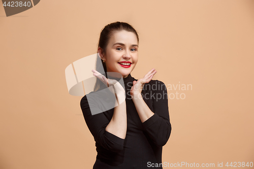 Image of The happy business woman standing and smiling against pastel background.