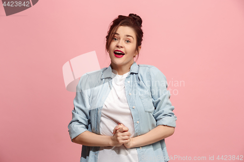 Image of The happy business woman standing and smiling against pink background.