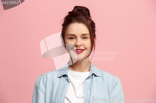 Image of The happy business woman standing and smiling against pink background.