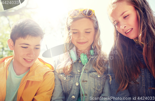 Image of three happy teenage friends headphones