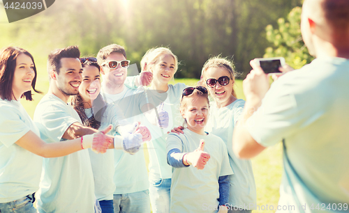 Image of group of volunteers taking picture by smartphone