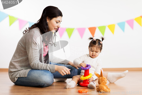 Image of mother and baby daughter playing with pyramid toy