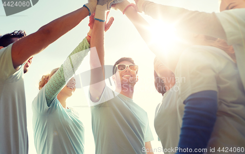 Image of group of volunteers making high five outdoors