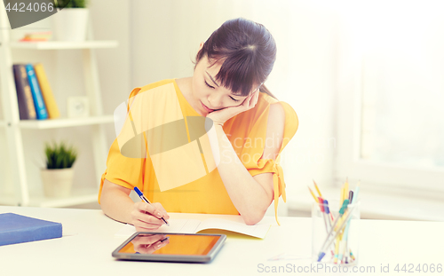 Image of bored asian woman student with tablet pc at home