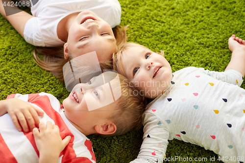 Image of happy little kids lying on floor or carpet