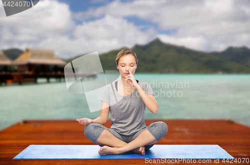 Image of woman making yoga in and meditating lotus pose