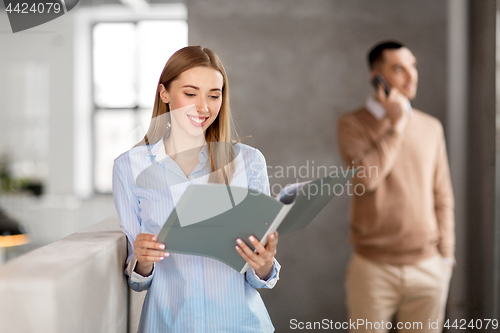 Image of smiling female office worker with folder