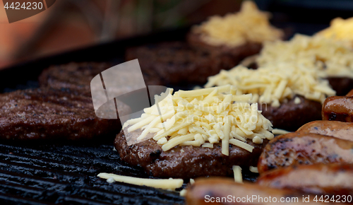 Image of Grated cheese piled on top of a barbecued beefburger