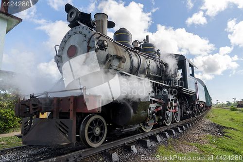 Image of Old steam locomotive or railway train arriving to the platform 