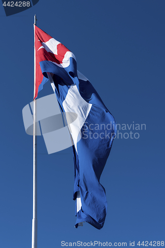 Image of Waving Cuba flag and blue sky