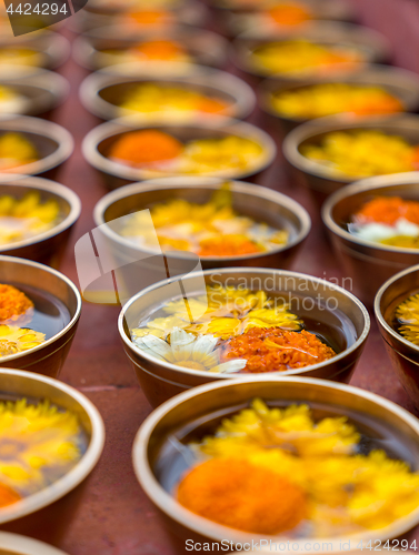 Image of Buddhist flower offerings or gifts in bowls and rows