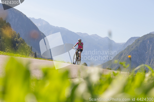 Image of Active sporty woman riding mountain bike in nature.