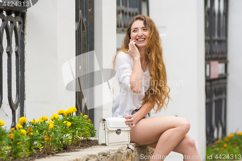 Image of Young girl having fun on the phone in the street