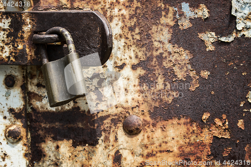 Image of Old blue rusty metal door with lock