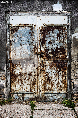 Image of Old blue rusty metal door with lock