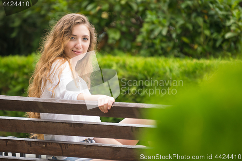 Image of Young girl in the park looked at the frame