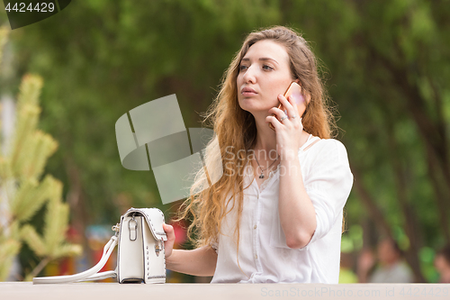 Image of Young girl with phone and handbag